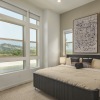 bedroom with big window and paintings above bed