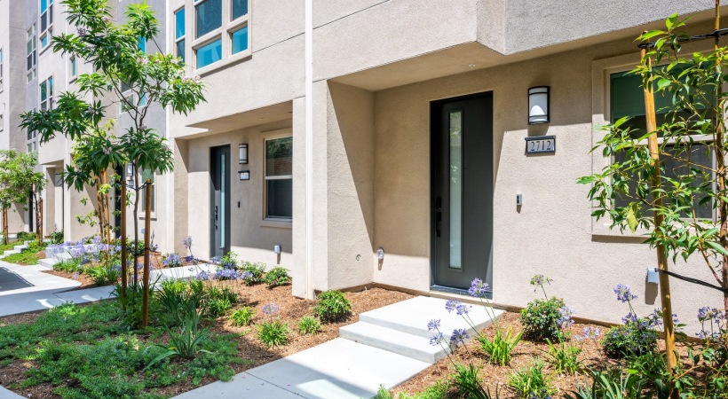 front of a building with trees a door and a walkway